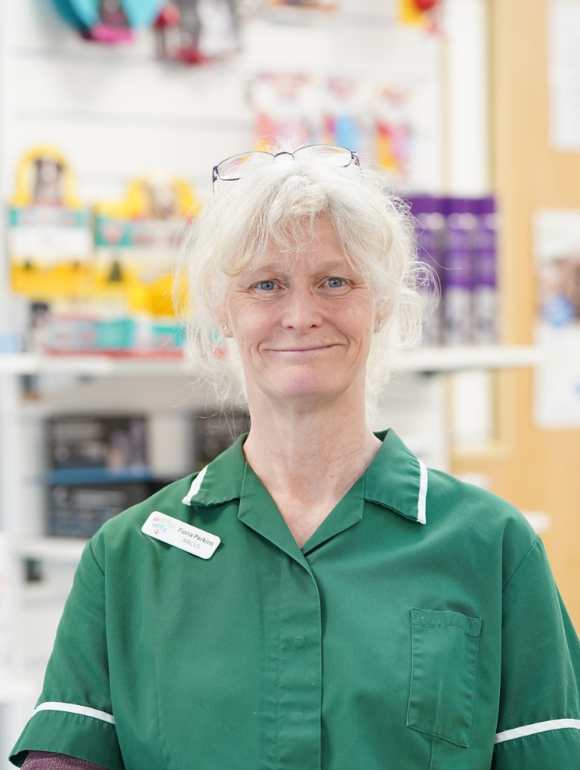 Vet with blonde hair tied back wearing green top